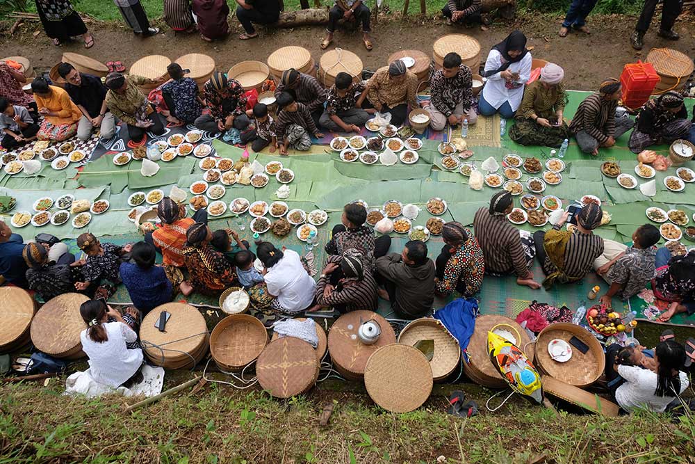 Sejumlah warga menyantap makanan bersama saat tradisi Nyadran Perdamaian di Krecek, Getas, Kaloran, Temanggung, Jateng, Jumat (27/1/2023). Tradisi Nyadran atau Merti Dusun yang dilaksanakan oleh warga lintas agama tersebut telah berlangsung sejak puluhan tahun silam yang bertujuan untuk mendoakan arwah leluhur sekaligus sebagai wujud kerukunan antar pemeluk agama. ANTARA FOTO/Anis Efizudin