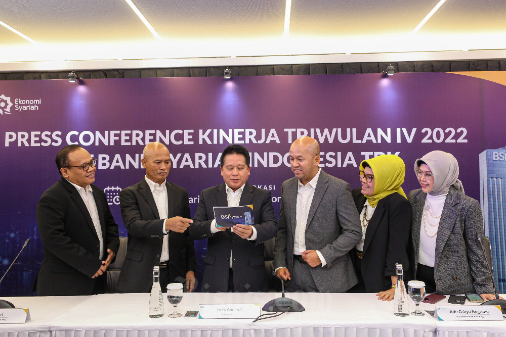 Direktur Utama PT Bank Syariah Indonesia Tbk (BSI) Hery Gunardi (ketiga kiri) berbincang dengan Direktur Information Technology BSI Achmad Syafii (kiri), Direktur Retail Banking BSI Ngatari (kedua kiri), Direktur Finance & Strategy BSI Ade Cahyo Nugroho (ketiga kanan), Direktur Risk Management BSI Tiwul Widyastuti (kedua kanan), dan Direktur Compliance & Human Capital BSI Tribuana Tunggadewi seusai paparan kinerja triwulan IV 2022 di Jakarta, Rabu (1/2/2023). Bisnis/Abdurachman rn