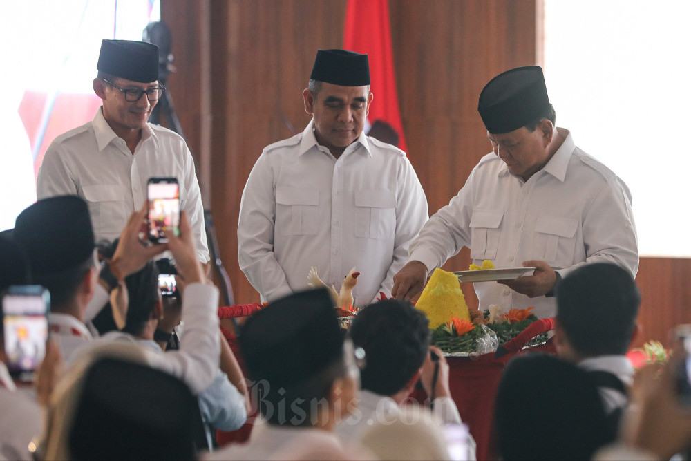 Ketua Umum Partai Gerindra Prabowo Subianto (kanan) disaksikan Wakil Ketua Dewan Pembina Sandiaga Uno (kiri) dan Sekretatis Jenderal Ahmad Muzani memotong tumpeng saat peringatan Hari Ulang Tahun (HUT) ke-15 Partai Gerindra di Jakarta, Senin (6/2/2023). Partai Gerindra menyelenggarakan peringatan HUT ke-15 yang diisi dengan rangkaian kegiatan sosial antara lain penyerahan santunan kepada anak yatim, layanan periksa kesehatan gratis, hingga donor darah. Pada kesempatan ini juga dilakukan konsolidasi internal guna memperkuat partai. Bisnis/Arief Hermawan P