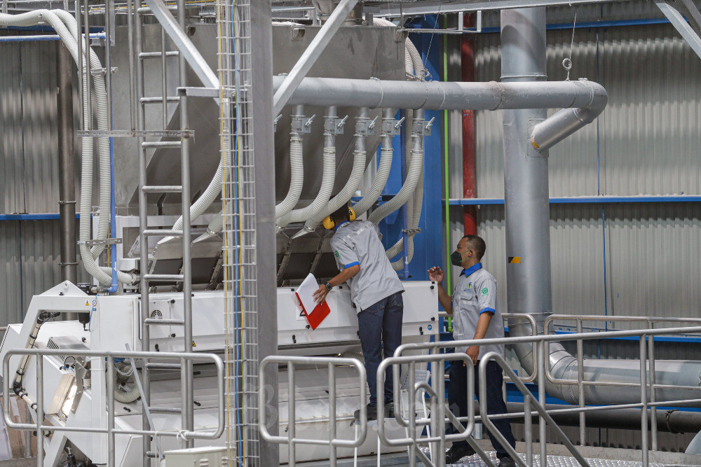 Pekerja memeriksa mesin produksi di Komplek Pabrik Daur Ulang Plastik PET Amandina Bumi Nusantara & Yayasan Mahija Parahita Nusantara, Bekasi, Jawa Barat, Rabu (8/2/2023). Bisnis/Abdurachman