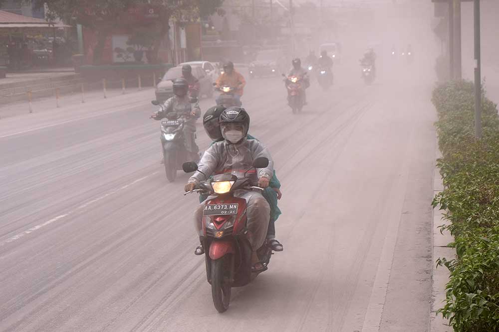 Sejumlah pengendara sepeda motor melintas di jalan utama kota Magelang yang diselimuti abu vulkanis gunung Merapi di Magelang, Jawa Tengah, Sabtu (11/3/2023). Gunung Merapi kembali memuntahkan awan panas guguran (APG) pada pukul 12.12 WIB yang mengakibatkan hujan abu yang mengarah ke barat laut dan utara, hujan abu dengan intensitas tinggi terjadi di Kota Magelang. ANTARA FOTO/Anis Efizudin