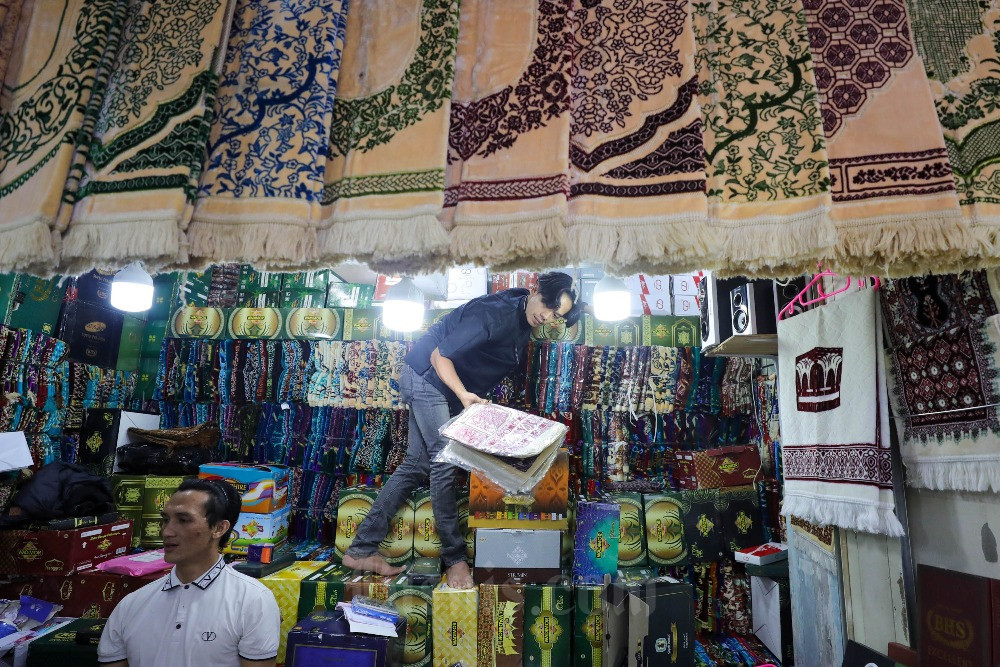 Pedagang melayani pembeli pakaian dan perlengkapan muslim di Pasar Tanah Abang, Jakarta, Rabu (29/3/2023). Memasuki pekan pertama bulan Ramadan, penjualan busana muslim masih terlihat normal. Para pedagang memprediksi, penjualan pakaian muslim baru akan diserbu oleh pengunjung pada sekitar dua minggu jelang Hari Raya Idul Fitri. Bisnis/Himawan L Nugraha