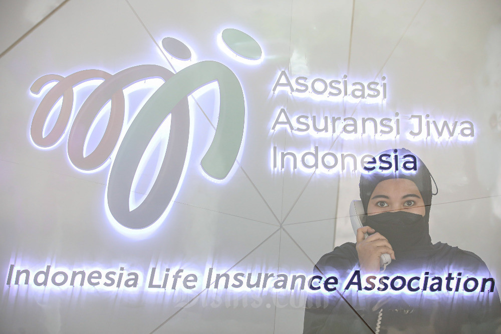 Karyawati beraktivitas di depan logo-logo perusahaan asuransi jiwa di Jakarta, Senin (5/6/2023). Ketua Dewan Pengurus Asosiasi Asuransi Jiwa Indonesia (AAJI) Budi Tampubolon mengatakan hasil investasi asuransi jiwa mengalami penurunan hingga 43 persen secara tahunan (year-on-year/yoy) sampai dengan akhir Maret 2023. Secara nominal menyusut dari Rp10,81 triliun pada kuartal I/2022 menjadi Rp6,16 triliun pada kuartal I/2023. Bisnis/Abdurachman