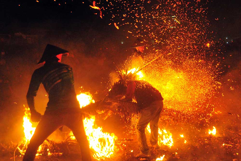 Peserta saling serang menggunakan obor saat tradisi perang obor di Desa Tegal Sambi, Tahunan, Jepara, Jawa Tengah, Senin (5/6/2023). Acara yang digelar setahun sekali sebagai wujud syukur masyarakat setempat kepada Tuhan Yang Maha Esa atas rezeki melimpah, kesehatan serta keselamatan itu diikuti 40 peserta dengan sebanyak 350 obor dijadikan alat perang. ANTARA FOTO/Yusuf Nugroho