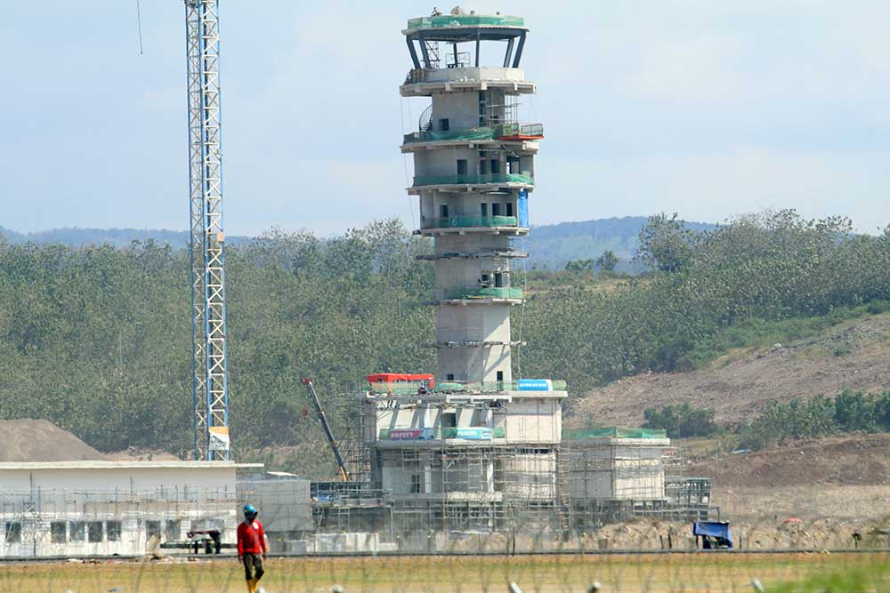 Pekerja beraktivitas pada proyek pembangunan Bandara Dhoho di Kediri, Jawa Timur, Selasa (6/6/2023). Proyek strategis nasional bandara pertama di Indonesia yang dibangun dengan pembiayaan swasta yang ditargetkan selesai pada akhir tahun 2023 tersebut akan dioperasikan oleh PT Angkasa Pura I sedangkan badan usaha pelaksana sekaligus pemilik aset PT Surya Dhoho Investama akan berperan sebagai pengelola bandara. ANTARA FOTO/Prasetia Fauzani