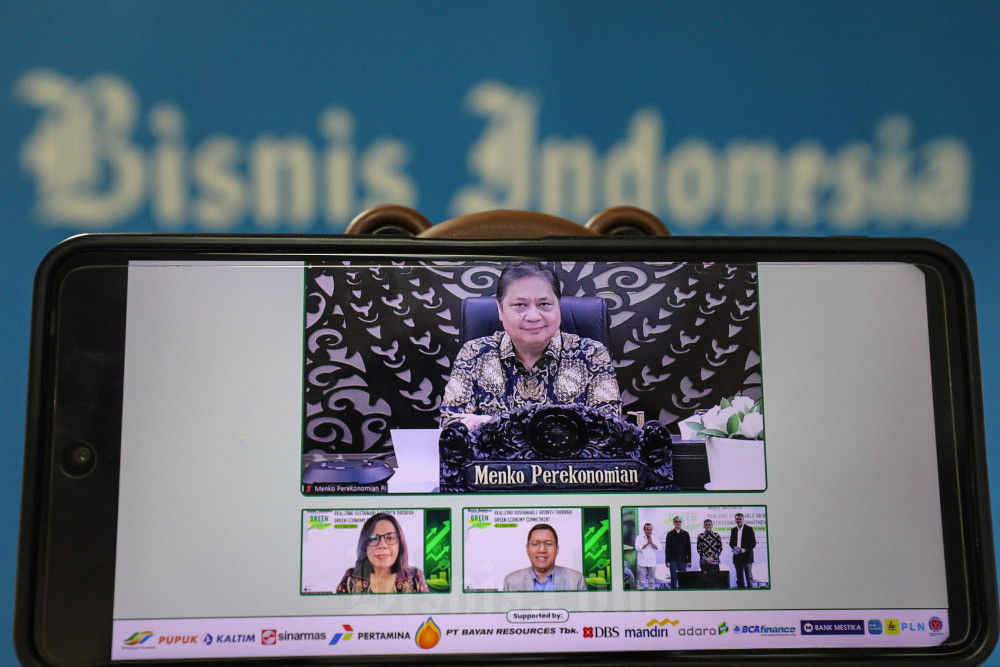 Layar menampilkan Menteri Koordinator Bidang Perekonomian Airlangga Hartarto (atas), Direktur Pemberitaan dan Produksi sekaligus Pemimpin Redaksi Bisnis Indonesia Maria Y. Benyamin (bawah dari kiri), Direktur Pemasaran Hery Trianto, Direktur PT Bisnis Indonesia Gagaskreasitama Chamdan Purwoko, Direktur Center of Economic and Law Studies Bhima Yudhistira, Direktur Utama PT Pupuk Kalimantan Timur Rahmad Pribadi, dan Wakil Pemimpin Redaksi Bisnis Indonesia Fahmi Achmad berfoto bersama secara virtual sebelum dimulainya diskusi panel Bisnis Indonesia Green Economy Forum 2023 hari kedua di Jakarta, Rabu (7/6/2023). Bisnis/Arief Hermawan P