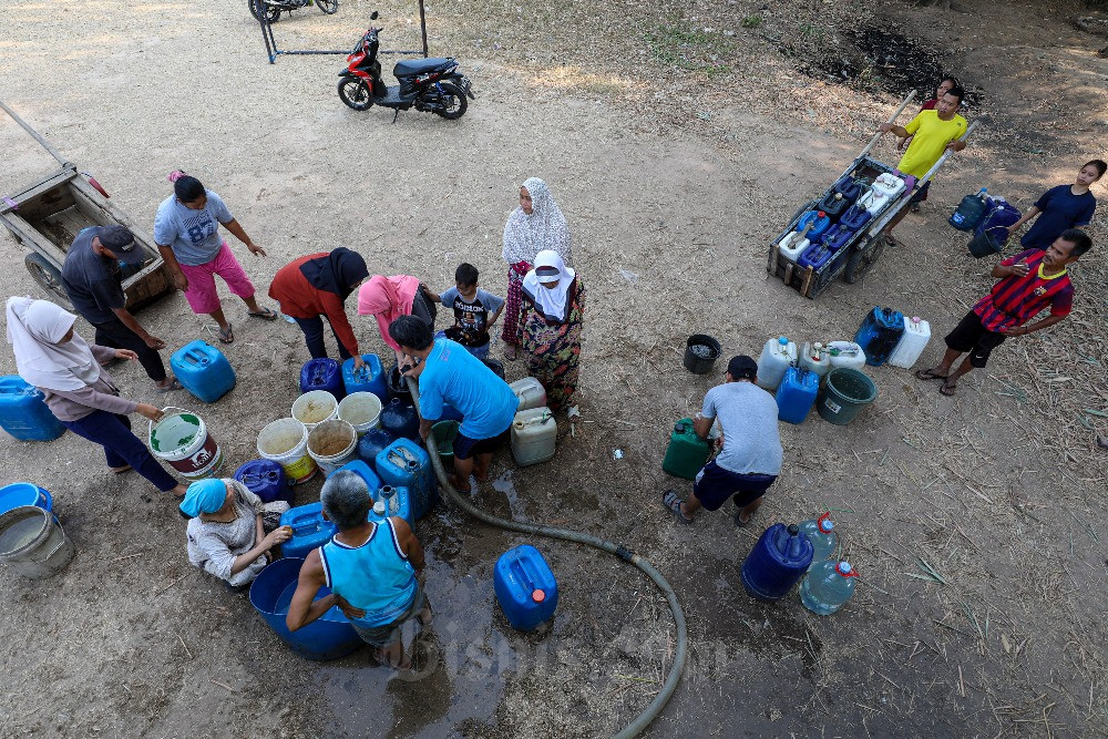 Warga menunggu pembagian air bersih di Bekasi, Jawa Barat, Minggu (17/9/2023). Badan Meteorologi dan Geofisika (BMKG) Stasiun Klimatologi Jawa Barat memprediksi, kekeringan terjadi hingga akhir November 2023. Kondisi kemarau saat ini juga dipicu oleh El Nino, namun statusnya masih lemah. Bisnis/Abdurachman