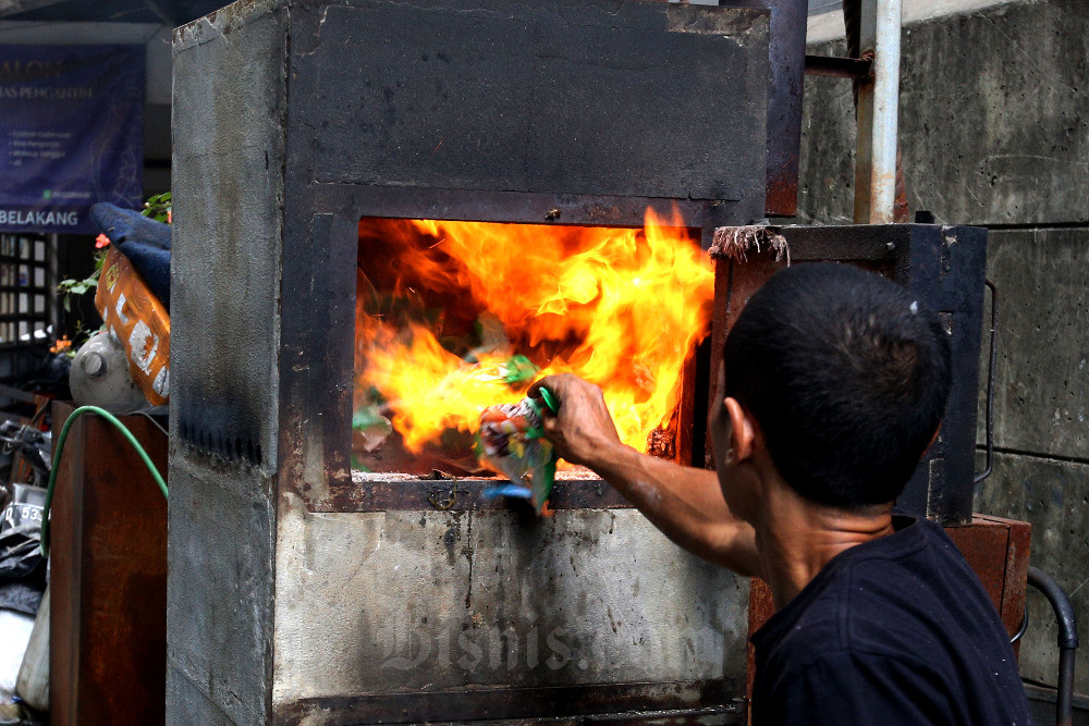 Yosef Barkah Ibrahim membakar sampah menggunakan insinerator ciptaannya di Kampung Warung Nangka, Cibaduyut, Bandung, Jawa Barat, Senin (18/9/2023). Warga Bandung, Yosef, secara swadaya berhasil menciptakan alat pemusnah sampah tanpa listrik, tanpa bahan bakar minyak, bahkan diklaim tanpa asap dengan pembakaran sempurna. Alat pemusnah sampah atau insinerator kreasinya yang diberi nama Jozef-R-700 ini telah dimanfaatkan untuk mengatasi sampah rumah tangga lebih dari 400 kepala keluarga di wilayah tempat tinggalnya. Insinerator Jozef-R-700 diharapkan bisa menjadi solusi sampah yang menumpuk di wilayah Bandung Raya beberapa waktu lalu akibat penutupan TPA Sarimukti yang mengalami kebakaran. Bisnis/Rachman