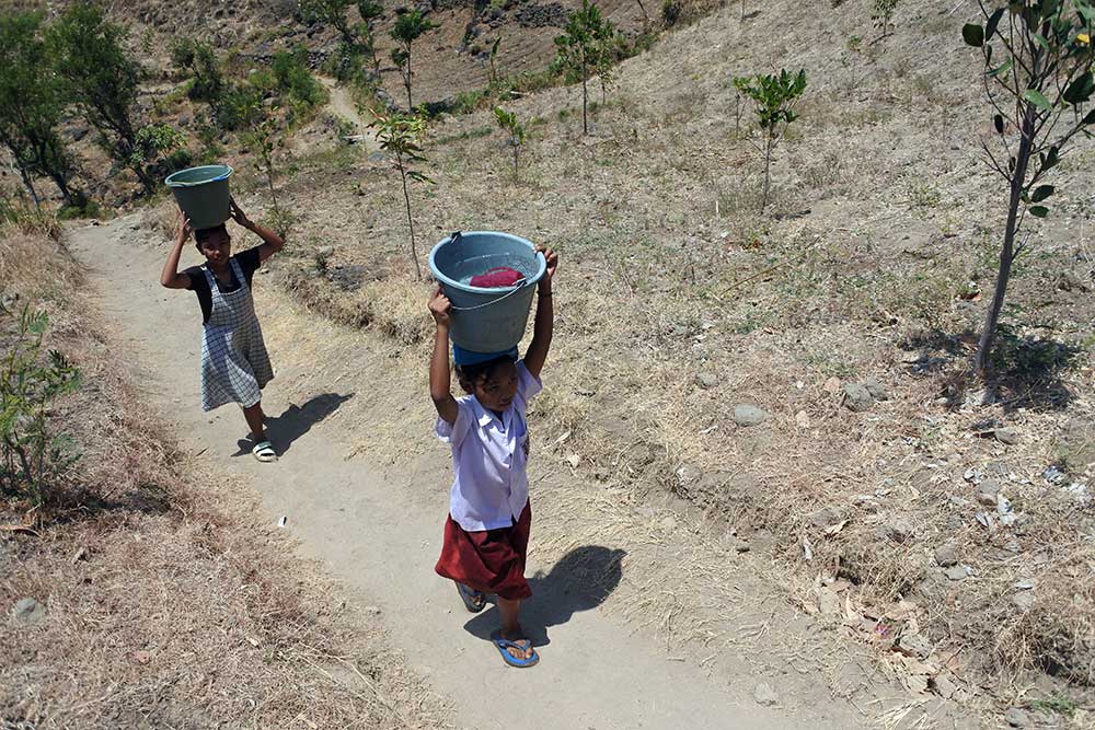 Dua anak membawa air dari sumber mata air di Desa Selomukti, Mlandingan, Situbondo, Jawa Timur, Senin (18/9/2023). Sebanyak 252 kepala keluarga Dusun Jerugen desa tersebut kesulitan air bersih untuk kebutuhan minum dan terpaksa mengambil air di sumber mata air dengan jarak sekitar dua kilometer dari rumahnya. ANTARA FOTO/Seno