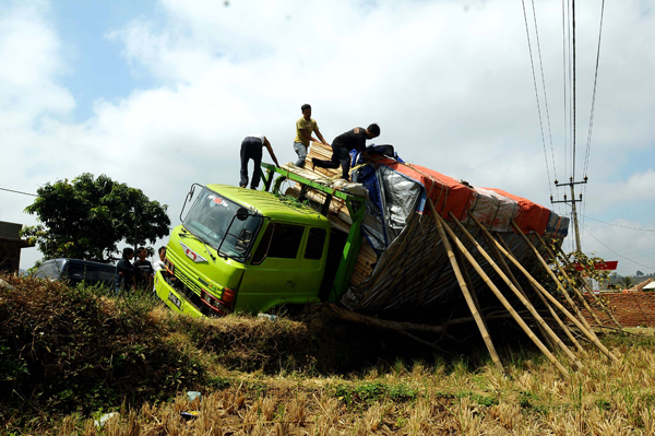  FOTO: Truk Muatan Kayu Terguling di Garut