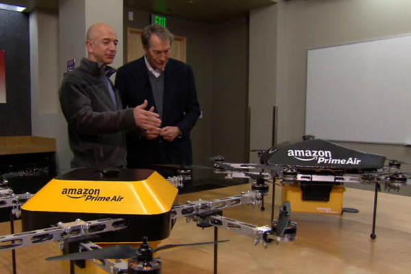 CEO Amazon Jeff Bezos (kiri) menjelaskan prototipe drone pengirim paket kepada Charlie Rose dari CBS./CBS 