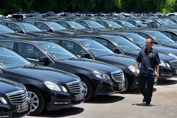 Seorang pria melintas di dekat deretan mobil yang akan digunakan rombongan Raja Arab Saudi Salman bin Abdulaziz al-Saud di kawasan Nusa Dua, Bali, Kamis (2/3)./.Antara-Fikri Yusuf