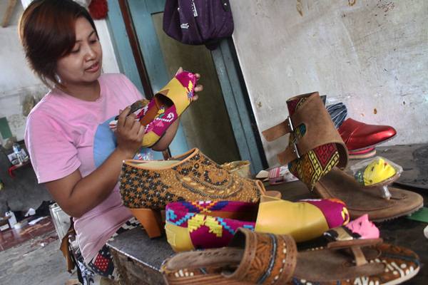 Perajin membuat sandal dan sepatu batik yang akan diekspor, di Polehan, Malang, Jawa Timur, Senin (11/1)./Antara-Ari Bowo Sucipto