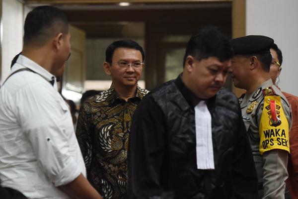 Terdakwa kasus dugaan penistaan agama Basuki Tjahaja Purnama (kedua kiri) berjalan memasuki ruang sidang di Auditorium Kementerian Pertanian, Jakarta, Selasa (7/3). Sidang ke-13 itu beragenda mendengarkan keterangan saksi-saksi yang meringankan terdakwa. ANTARA FOTO/Akbar Nugroho Gumay