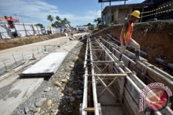 Pekerja menyelesaikan proyek underpass atau jalan bawah tanah di simpang lima Bandara Internasional Sultan Hasanuddin yang berada di perbatasan Kota Makassar-Kabupaten Maros, Makassar, Sulawesi Selatan, Kamis (3/3/2017)/Antara-Dewi Fajriani