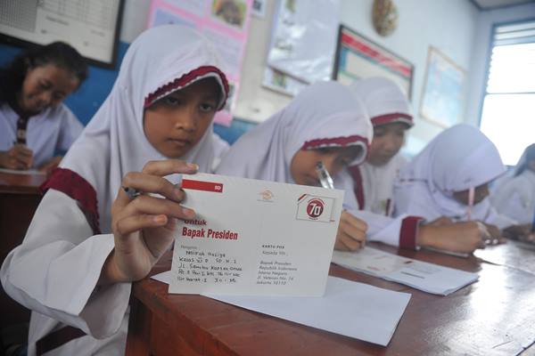 Ilustrasi: Siswi Sekolah Dasar membaca ulang surat yang akan mereka kirimkan kepada Presiden Joko Widodo di ruang kelas Sekolah Dasar Negeri 1 Palembang, Kamis (20/8)./Antara