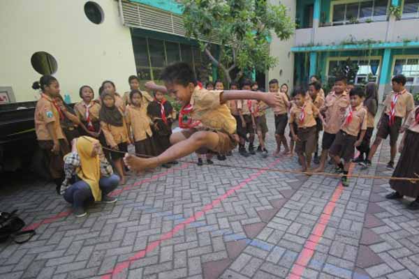 Sejumlah murid kelas 3 dan 4 SD Negeri 4 Rangkah, Surabaya, bermain lompat tinggi selepas jam sekolah di halaman sekolah mereka, di Surabaya, Jumat (5/5/2017). Kegiatan bermain permainan tradisional seperti tarik tambang, lompat tinggi, balap karung tersebut digagas Komunitas Kampoeng Dolanan Surabaya dengan tujuan untuk memasyarakatkan kembali permaianan tradisional sebagai salah satu khazanah budaya Nusantara./ANTARA
