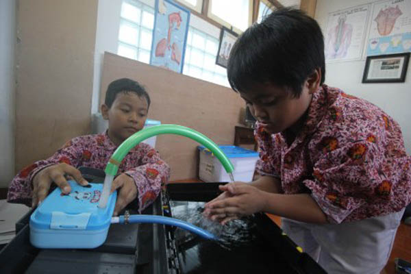 Murid SD Muhammadiyah 4 Surabaya Cakra Wangsa (kanan) dan Aushafal FY (kiri) memeragakan alat wudu portabel di Surabaya, Rabu (10/5/2017)./ANTARA