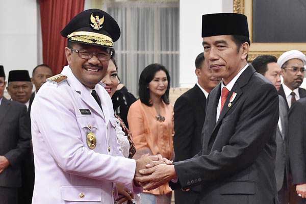 Presiden Joko Widodo (kanan) memberi ucapan selamat kepada Gubernur DKI Jakarta Djarot Saiful Hidayat (kiri) beserta istri, seusai pelantikan di Istana Negara, Jakarta, Kamis (15/6)./Antara-Puspa Perwitasari.