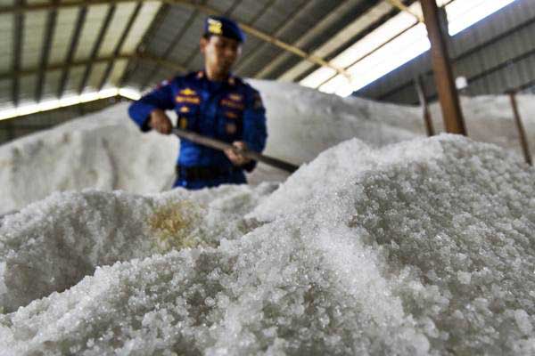 Petugas memeriksa timbunan garam milik PT Garam (persero) yang disegel di dalam gudang oleh Tim Satgas Pangan Mabes Polri di Gresik, Jawa Timur, Rabu (7/6)./Antara-Zabur Karuru