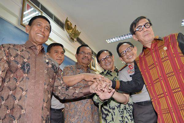 Menko Polhukam Wiranto (kiri) bersama MenkumHAM Yassona Laoly (dari kanan), Kapolri Jenderal Polisi Tito Karnavian, Seskab Pramono Anung, Jaksa Agung Prasetyo, serta Inspektorat Pengawasan Umum (Irwasum) Polri Komjen Pol Dwi Priyatno, menyatukan tangan bersama seusai memaparkan Perpres Nomor 87 Tahun 2016 tentang Pembentukan Satuan Tugas Sapu Bersih Pungutan Liar yang telah ditandatani Presiden Joko Widodo di Jakarta, Jumat (21/10)./Antara-Yudhi Mahatma