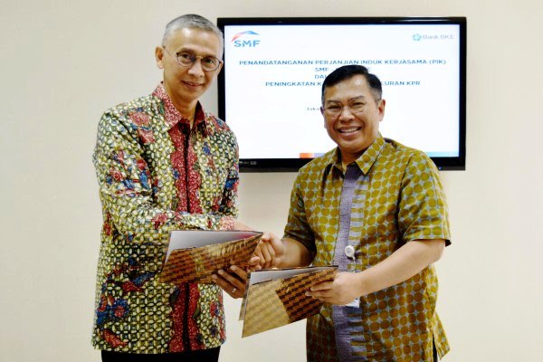 Direktur Utama SMF Ananta Wiyogo (kanan) bertukar dokumen dengan Direktur Operasional Bank BKE Zainal Riffandi seusai menandatangani Perjanjian Induk Kerja Sama terkait peningkatan kapasitas penyaluran Kredit Pemilikan Rumah (KPR) Bank BKE di Grha SMF, Jakarta pada Rabu (2/8).