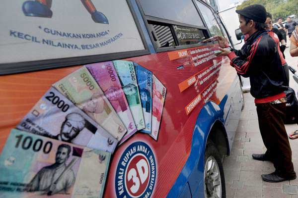 Warga menukarkan uang pecahan pada layanan mobil kas keliling Bank Indonesia di Lapangan IRTI, Monas, Jakarta, Senin (5/6)./Antara-Sigid Kurniawan