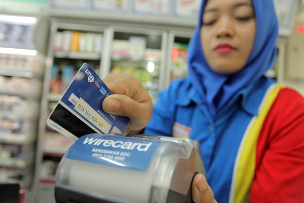 Karyawan minimarket menggesekan kartu debit di mesin Electronic Data Capture (EDC), di Jakarta, Selasa (5/9). Bank Indonesia melarang penggesekan ganda (double swipe) dalam transaksi nontunai dalam setiap transaksi./ANTARA-Muhammad Adimaja