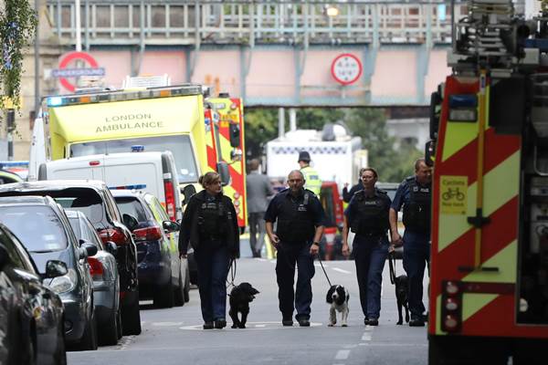 Polisi dan anjing pelacak melakukan pemeriksaan di sekitar lokasi ledakan, di stasiun kereta api bawah tanah Parsons Green di London./Reuters