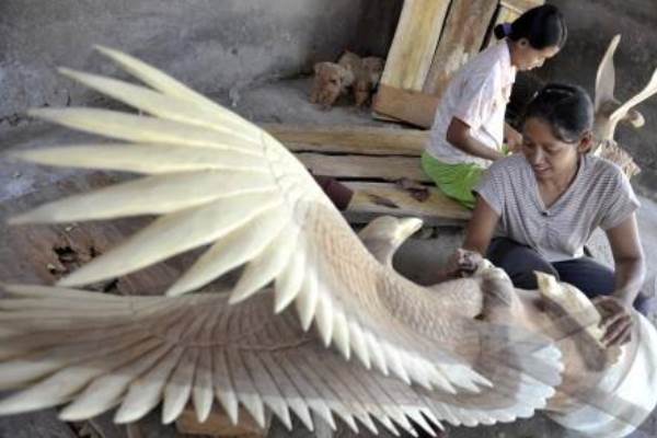 Dua perajin menyelesaikan proses akhir dari pembuatan kerajinan patung rajawali di Desa Pering, Gianyar, Bali./Antara-Nyoman Budhiana