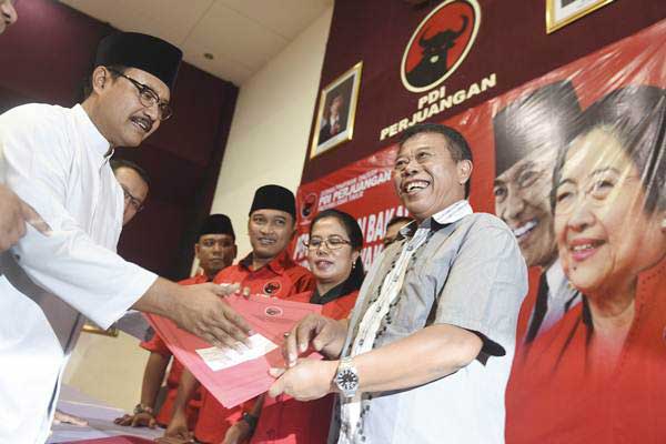 Ketua DPD PDIP Jatim Kusnadi (kanan) menerima pengembalian formulir bakal calon Gubernur Jatim dari Wakil Gubernur Jawa Timur Saifullah Yusuf (kiri) di kantor DPD PDIP Jatim, Surabaya, Jawa Timur, Senin (3/7).ANTARA-Zabur Karuru