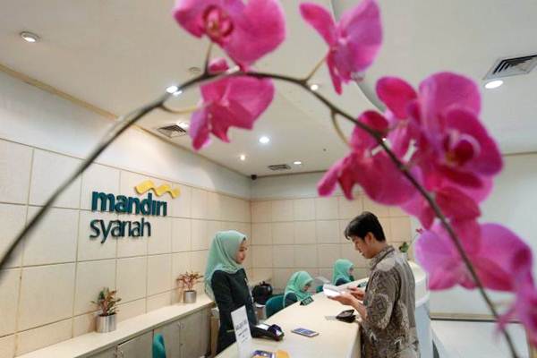 Karyawan melayani nasabah di banking hall PT Bank Syariah Mandiri (BSM) di Jakarta./JIBI-Dwi Prasetya