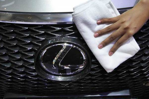 Pekerja membersihkan logo mobil Lexus, di Jakarta./JIBI-Dedi Gunawan