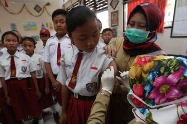 Petugas medis memberikan imunisasi difteri kepada murid Sekolah Dasar (SD)./Antara