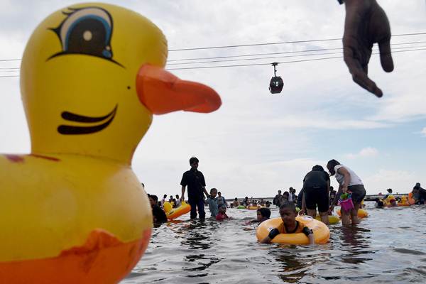 Pengunjung bermain di pantai Ancol, Jakarta, Senin (26/6)./Antara-Sigid Kurniawan
