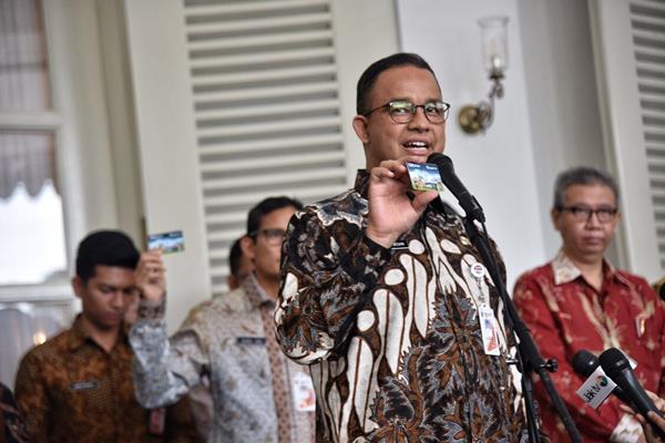 Gubernur DKI Jakarta Anies Baswedan memperlihatkan kartu Ok-Otrip