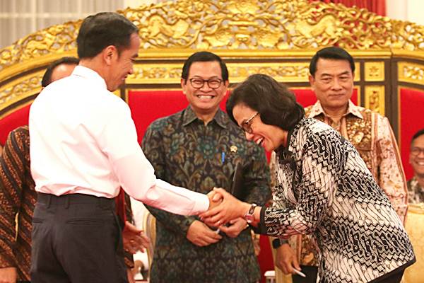 Presiden Joko Widodo (kiri) memberikan ucapan selamat kepada Menteri Keuangan Sri Mulyani (kanan) yang terpilih sebagai Menteri terbaik di dunia (Best Minister in the World Award), di Istana Negara, Jakarta, Senin (12/2/2018)./Setkab-Rahmat