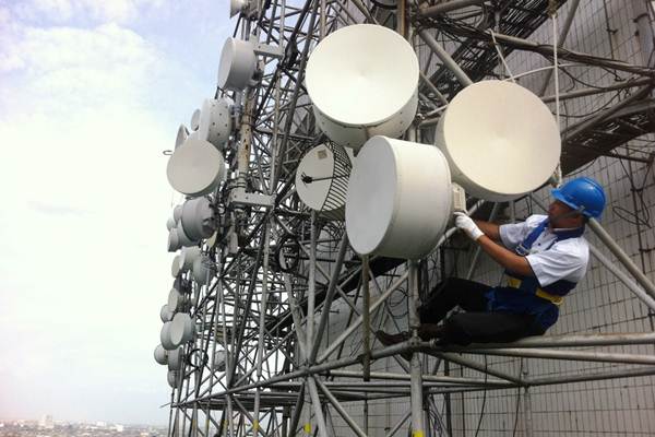 Teknisi PT Indosat Tbk. melakukan perawatan base transceiver station (BTS) di gedung tinggi/Indosat