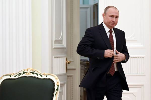Presiden Rusia Vladimir Putin memasuki aula untuk bertemu dengan kandidat yang berpartisipasi dalam pemilihan presiden sesi terakhir, di Kremlin di Moskow./Reuters