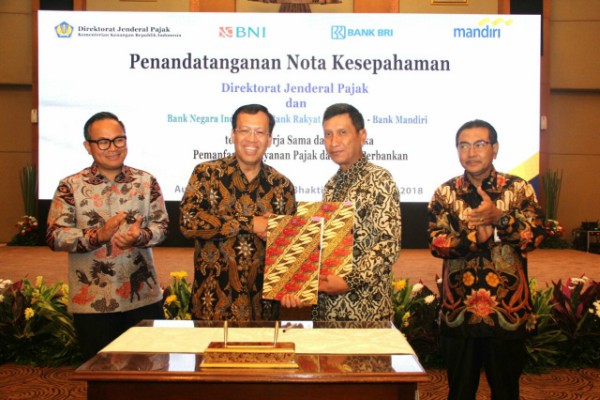 Wakil Direktur BNI Herry Sidharta dan Direktur Jenderal Pajak Robert Pakpahan bersalaman seusai menandatangani nota kesepahaman di Jakarta, Rabu (18/4/2018). (Bisnis/Abdul Rahman)