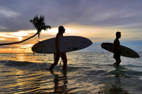 Siluet wisatawan mancanegara membawa papan surfing (selancar), di Pantai Mapadegat, Kepulauan Mentawai, Sumatra Barat, Rabu (4/10)./ANTARA-Iggoy el Fitra