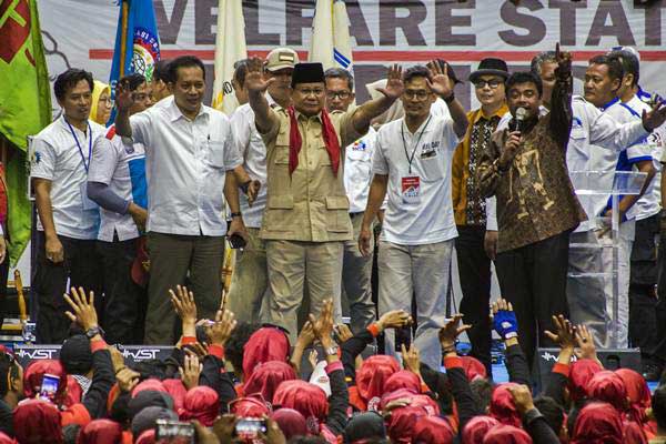 Ketua Umum Partai Gerindra Prabowo Subianto (tengah) bersama Presiden Konfederasi Serikat Pekerja Indonesia (KSPI) Said Iqbal (kanan) berorasi saat aksi Hari Buruh Internasional di Istora Senayan, Jakarta, Selasa (1/5/2018)./ANTARA-Galih Pradipta