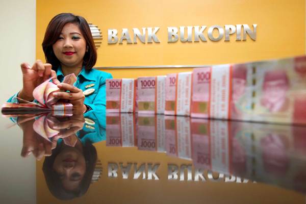 Karyawati menghitung uang rupiah, di kantor Cabang Bank Bukopin di Jakarta, Senin (9/4/2018)./JIBI-Abdullah Azzam