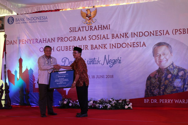 Gubernur Bank Indonesia (BI), Perry Warjiyo (kiri) memberikan bantua program sosial secara simbolis kepada Kepala SMPN 1 Gatak, Muh. Akrom (kanan) di sekolah setempat, Senin (18/6)./Bisnis-Bony Eko W.