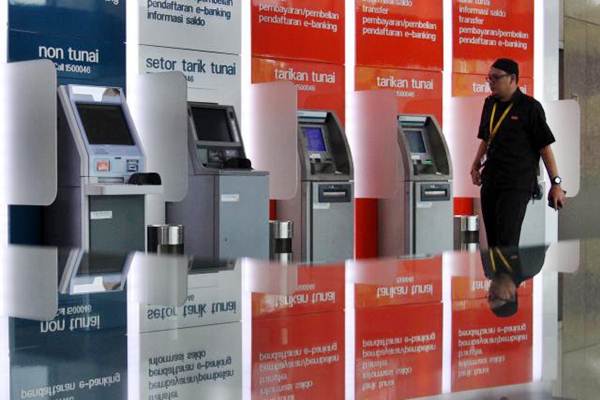 Nasabah melintas di dekat mesin ATM Bank BNI di Jakarta, Selasa (12/9)./JIBI-Abdullah Azzam