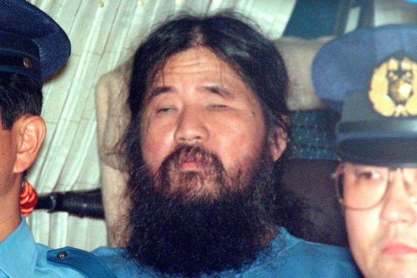 Pemimpin sekte Aum Shinrikyo Shoko Asahara duduk di dalam mobil polisi setelah diinterogasi di Tokyo, Jepang pada 25 September 1995./Kyodo via Reuters