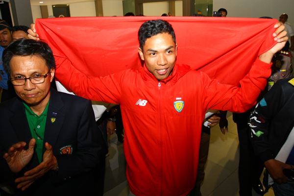 Atlet Indonesia juara dunia atletik nomor Lari 100 meter U-20 Lalu Muhammad Zohri (kanan) membentangkan Bendera Merah Putih setibanya dari Finlandia di Bandara Internasional Soekarno Hatta, Tangerang, Banten, Selasa (17/7)./Antara