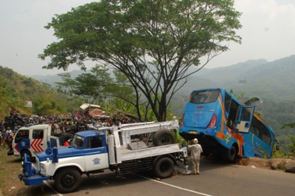 Petugas mengevakuasi bus berpenumpang puluhan wisatawan yang masuk jurang di Tanjakan Letter S, Kampung Bantarselang, Kecamatan Cikidang, Sukabumi, Jawa Barat, Minggu (9/9/2018)./Antara-Budiyanto