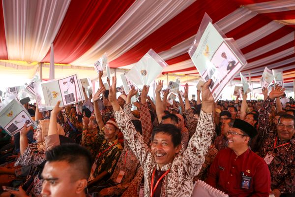 Warga menunjukkan sertifikat tanah saat mengikuti penyerahan sertifikat hak atas lahan tanah oleh Presiden Joko Widodo di pelataran Benteng Kuto Besak (BKB), Palembang, Sumatra Selatan, Jumat (13/7)./ANTARA FOTO-Nova Wahyudi