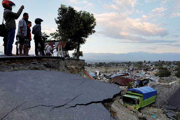 Warga mengamati area yang terdampak gempa di Balaroa, Palu, Sulawesi Tengah, Senin (1/10/2018)./Reuters-Beawiharta